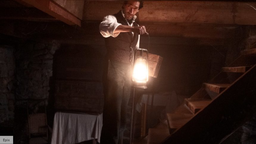 man holding a lantern on a flight of stairs