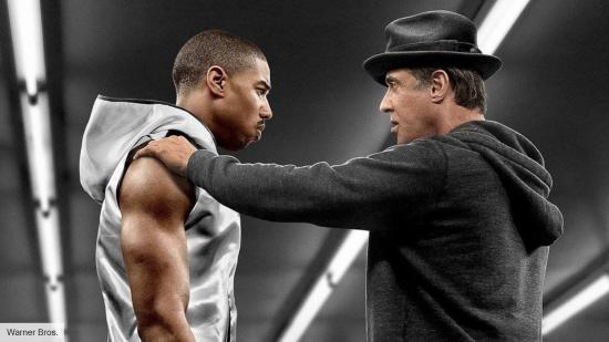 Rocky holding the shoulder and speaking to Adonis Creed