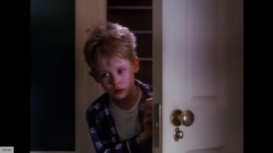 Where to Watch Home Alone: image shows a still from the fist movie with Kevin looking though a door.