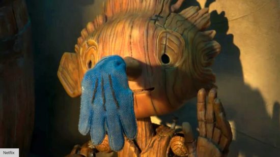 Pinocchio review: Pinocchio with a blue glove of his wooden nose