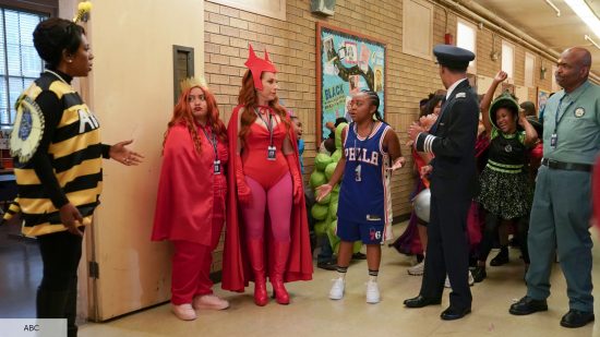 Melissa, Barbara, and Mr Johnson stand with students in Halloween costumes