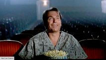 best John Carpenter movies: A man in eating popcorn in the film In the Mouth of Madness