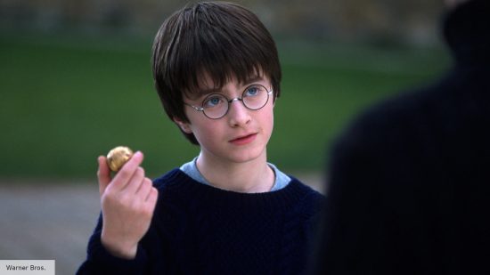 Harry Potter (Daniel Radcliffe) holds a golden snitch 