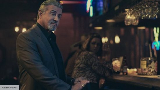 Tulsa King season 2 release date: Sylvester Stallone as Dwight Manfredi standing next to a bar in Tulsa King season 1