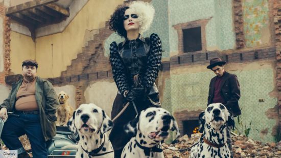 Emma Stone as Cruella in the 2021 movie, Cruella, holding a pack of dogs on a leash 