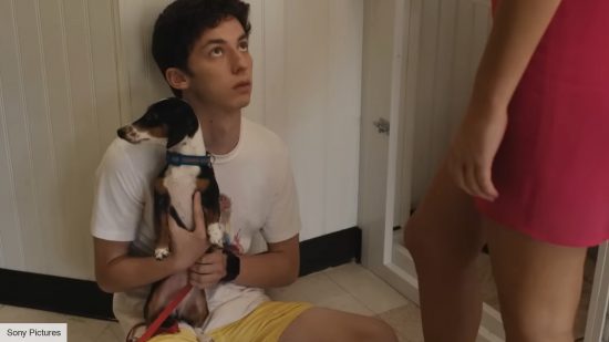 No Hard Feelings director interview: Andrew Feldman as Percy holding a puppy in No Hard Feelings