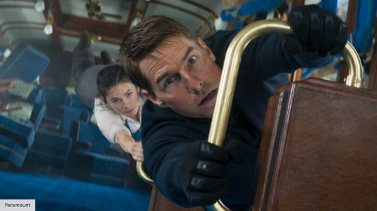 Tom Cruise and Hayley Atwell hanging from a train set after a crash in Mission: Impossible 7