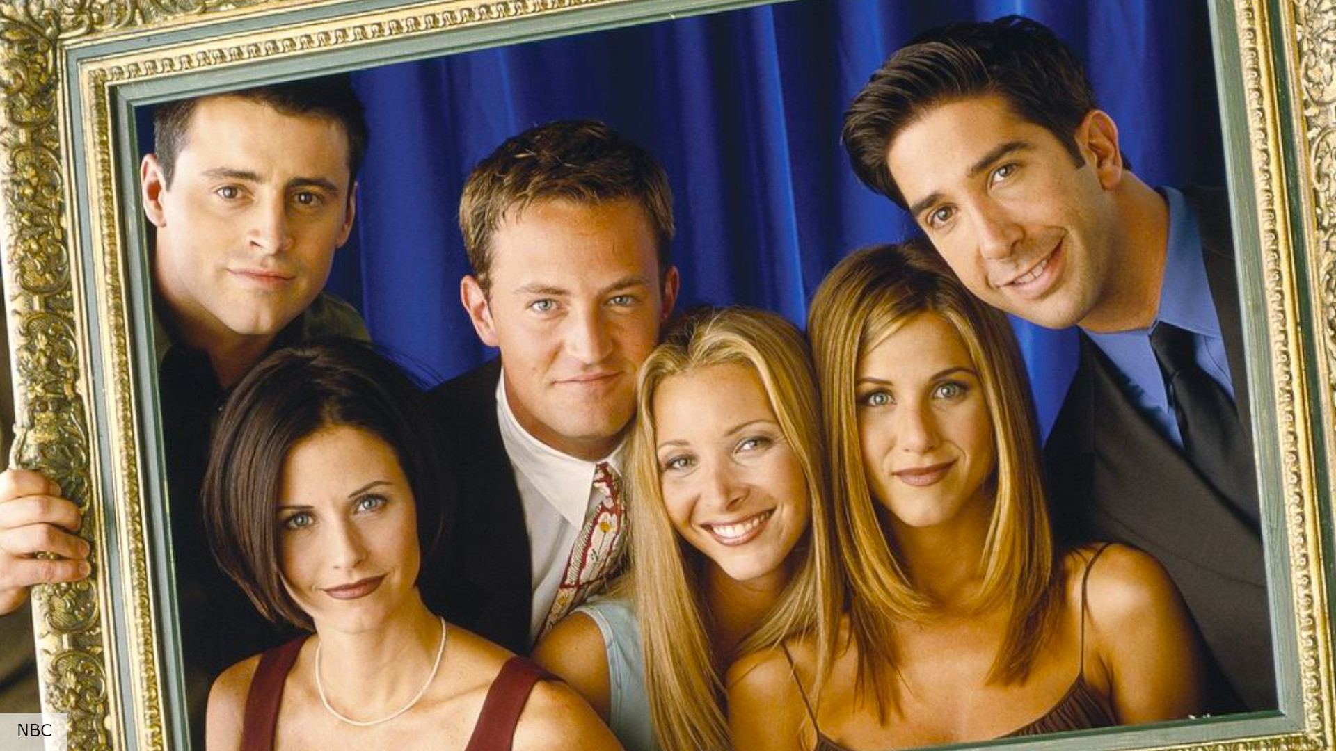 The cast of Friends holding up a picture frame